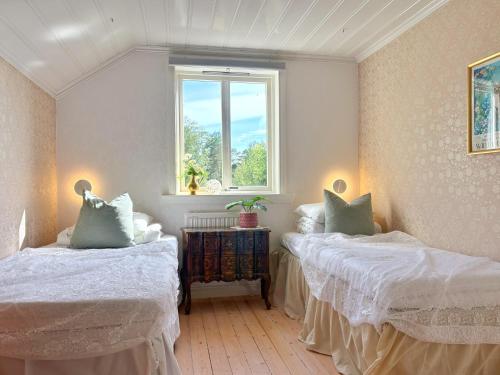 a bedroom with two beds and a window at The Nordby Cabin - Bed Linen Included - 3 minutes from E6 in Strömstad