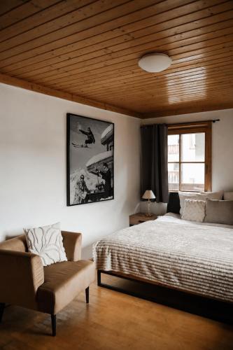 a bedroom with a bed and a chair at Center Chalet in Mayrhofen