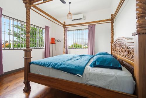 a bedroom with a canopy bed with blue sheets at Ruum1 Sugars Houz in Johor Bahru