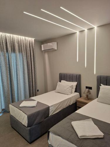 a hotel room with two beds with towels on them at Alykes Maisonette Prv Jacuzzi in Kontokali