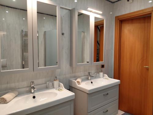 a bathroom with two sinks and two mirrors at B&B Piazza Marconi in Castelpizzuto