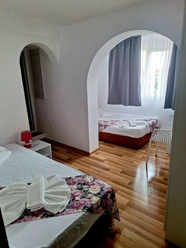 a bedroom with two beds and an arched window at Chance Sarafovo in Burgas