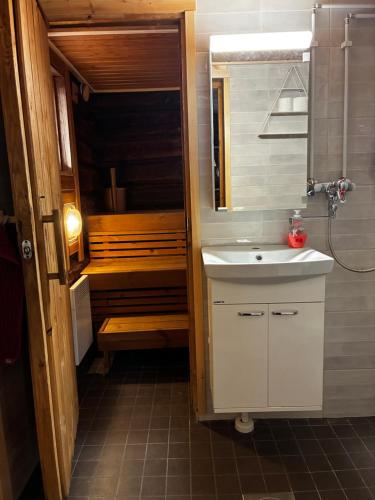 a small bathroom with a sink and a tub at Linkkumylly Cottages in Mäntyharju