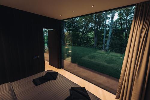 a bedroom with a bed and a large window at Stars Resort Sigulda in Sigulda