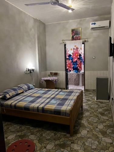 a bedroom with a bed and a painting on the wall at Furyan Lodge in Cape Coast
