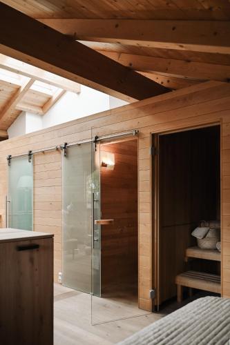 a glass shower in a bedroom with a wooden ceiling at Center Chalet in Mayrhofen