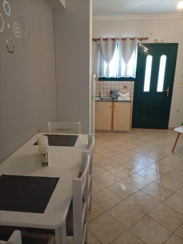 a kitchen with a white table and a green door at Danai in Tsoukalades