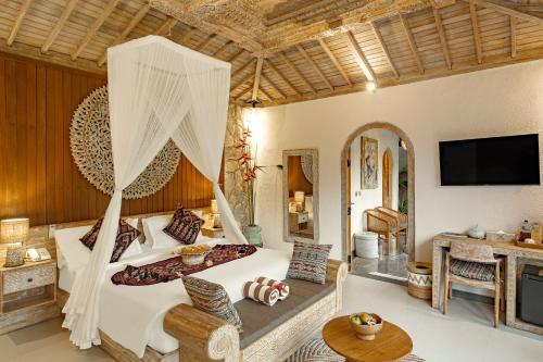 a bedroom with a bed and a living room at Legong Sebatu Villa in Ubud