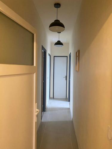 a hallway with an open door and a hallwayngthngthngthngthngthngthngth at Maison Pro Le Blanc - 3 chambres plus un canapé lit in Le Blanc