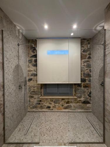 a large screen in a bathroom with a shower at ARCHONTIKO Atsas - Amethystos in Kalymnos