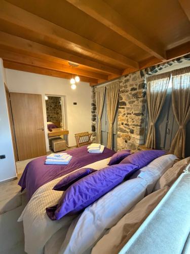 a bedroom with a large bed with purple pillows at ARCHONTIKO Atsas - Amethystos in Kalymnos