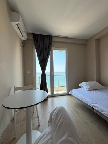 a room with a bed and a table and a window at CoastAL Hotel Shengjin in Shëngjin