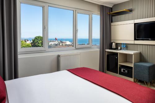 a hotel room with a bed and windows at Sultanahmet Nu Hotel in Istanbul
