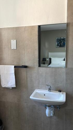 a bathroom with a sink and a mirror at No75 Stays in Tlokweng