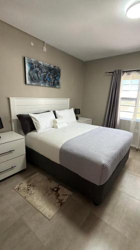 a bedroom with a large bed and a window at No75 Stays in Tlokweng