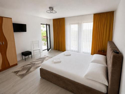 a bedroom with a large bed and a couch at A&D House in Novaci-Străini