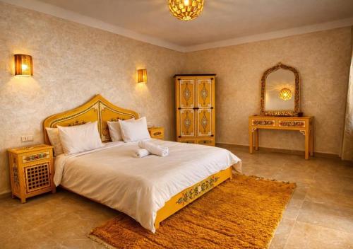a bedroom with a bed with a teddy bear on it at Dar Benyahya in Aït Zat