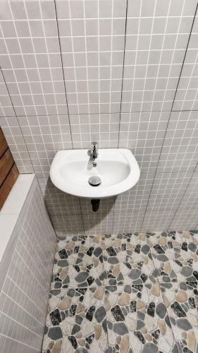 a bathroom with a sink and a tiled floor at Garden Cottage in Gili Gede