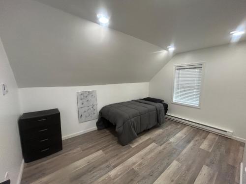 a bedroom with a bed and a dresser in it at Loft Apartment by the River Fort Edward in Fort Edward