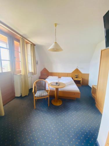 a bedroom with a bed and a table and a chair at Hotel Lengsteinerhof in Longostagno