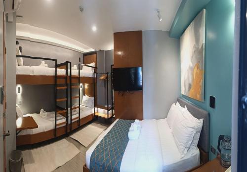 a bedroom with two bunk beds and a television at ECL Travellers Inn in Nabas