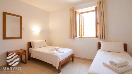 a room with two beds and a window at Apartamentos Panamá in Puerto Rico de Gran Canaria