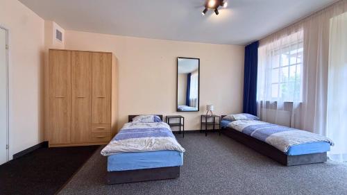 a bedroom with two beds and a mirror at Noclegi Słodki Sen 2 in Lublin