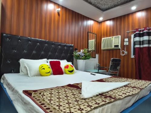 a bedroom with a bed with smileys pillows on it at T & G Guest House in Patna