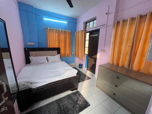 a bedroom with blue and pink walls and a bed at Kashiyana in Varanasi