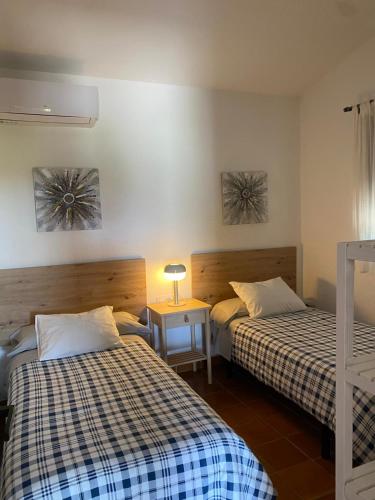 a room with two beds and a table with a lamp at Finca Dos Vientos Tarifa in Tarifa