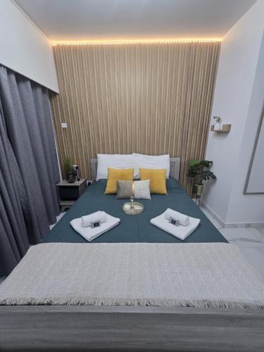 a bedroom with a large bed with two towels on it at Marble Coast Studio Apartment in Larnaca