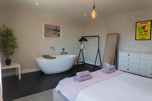 a bathroom with a tub and a bed and a sink at Boutique-Style Apartment in Heart of Brighton Lanes in Brighton & Hove