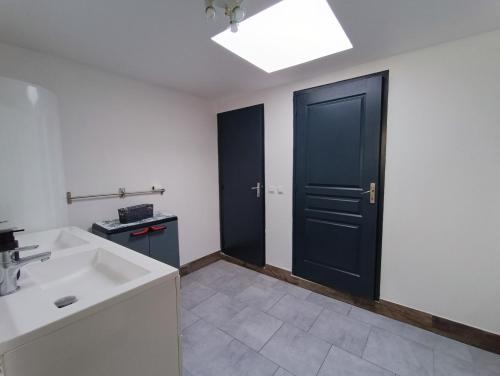 a bathroom with a black door and a sink at La Courée d'Orchies in Loos