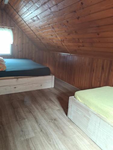 a room with two beds in a wooden cabin at Srub v lese in Hrabŭvka