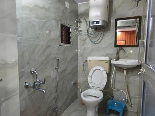 a bathroom with a toilet and a sink and a shower at T & G Guest House in Patna