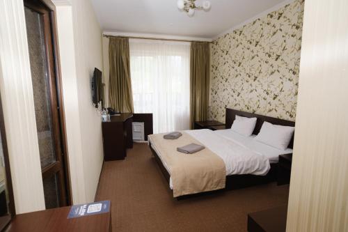 a hotel room with a large bed and a window at Kasimir Hotel & SPA in Bukovel