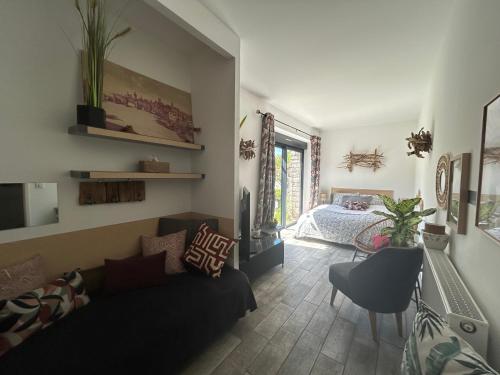 a living room with a couch and a bedroom at Maison en pierre in Saint-Cyr