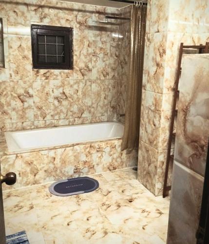 a bathroom with a shower and a tub and a sink at Charming Stone Cottage in erstwhile grape gardens in Secunderabad