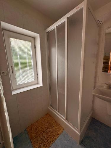 a bathroom with a shower and a sink and a window at Chalupa v Beskydech in Trojanovice