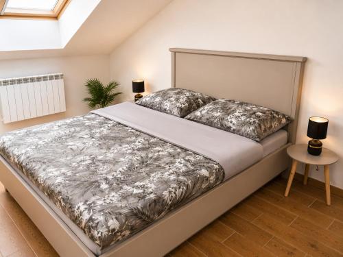 a bedroom with a bed with silver sheets and pillows at Apartament Dolina Baryczy in Żmigród