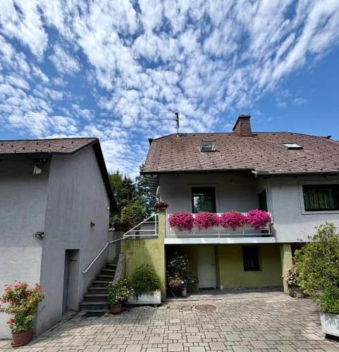a house with flowers on the balconies of it at Sabes Ferienwohnung in Altglandorf