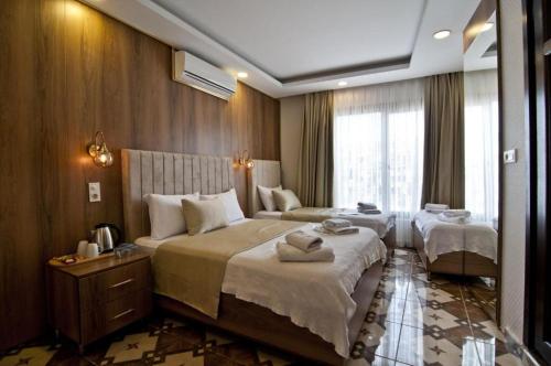 a hotel room with two beds and a window at lord ımmortelle apartment in Istanbul