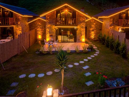 a house at night with lights in the yard at Dolana Wadi Taş Evleri in Pirinçlik