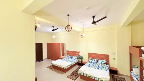 a hospital room with two beds and two ceiling fans at Platform 9 3by4 in Ujjain