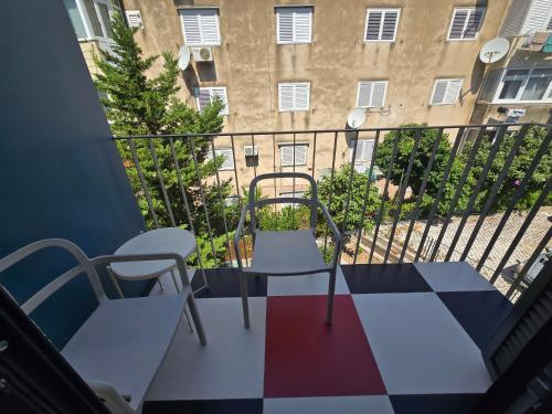a balcony with a table and chairs and a building at SUBTUB Hostel Makarska in Makarska