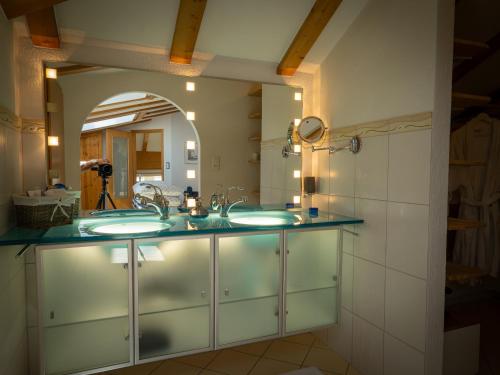 a bathroom with two sinks and a mirror at 280m2 Luxus Loft Atrium-X 60m2 Terrasse in Rorbas
