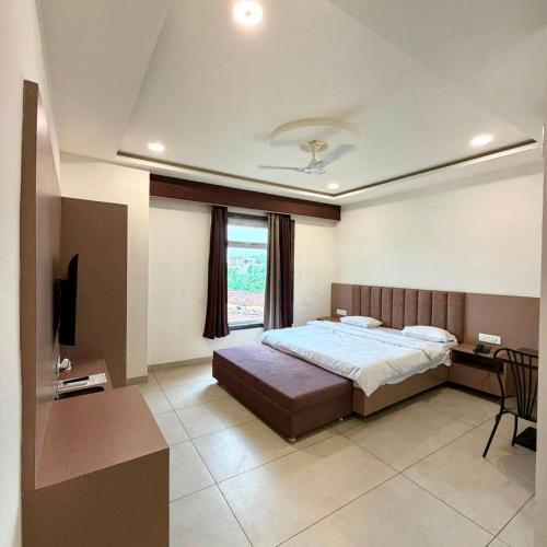 a bedroom with a bed and a desk and a television at City Palace Sagar in Sāgar