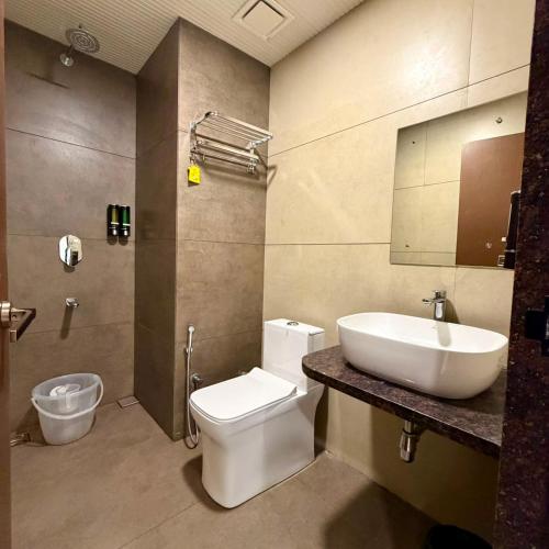 a bathroom with a sink and a toilet and a mirror at City Palace Sagar in Sāgar