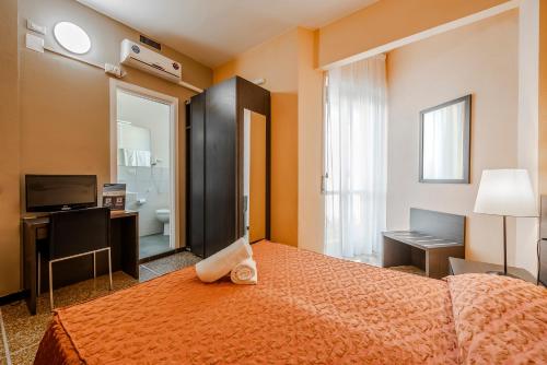 a hotel room with a bed and a television at Hotel Palace in Varazze