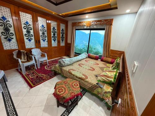 a bedroom with a bed and a large window at Galiyat Peak in Abbottabad